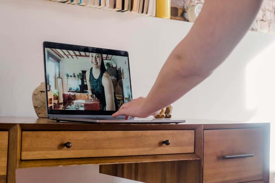 Une personne en séance visio avec un éducateur, ordinateur portable dans un intérieur chaleureux